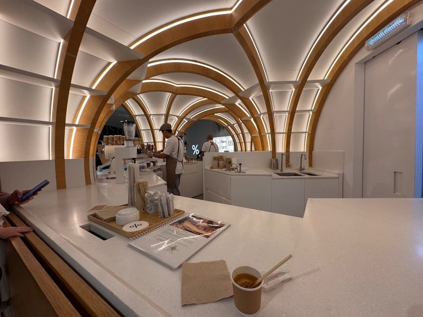 Una persona che scrive su un taccuino in un caffè dall'atmosfera calda e accogliente.